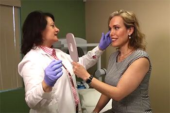 A female patient reviewing the results of a filler treatment with Dr. Berbari